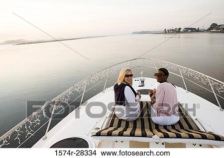 Portrait of friends relaxing on the deck of a boat View Large Photo Image Picture - Portrait of friends relaxing on the deck of a boat. Fotosearch