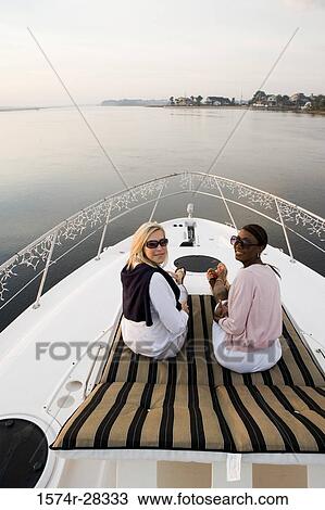 Portrait of friends relaxing on the deck of a boat View Large Photo Image Stock Image - Portrait of friends relaxing on the deck of a boat. Fotosearch