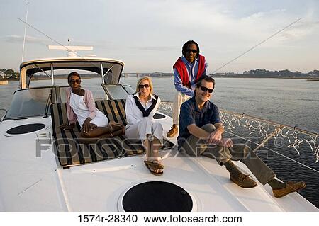 Portrait of friends relaxing on the deck of a boat View Large Photo Image Stock Image - Portrait of friends relaxing on the deck of a boat. Fotosearch