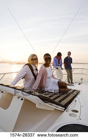 Portrait of friends relaxing on the deck of a boat View Large Photo Image Stock Photo - Portrait of friends relaxing on the deck of a boat. Fotosearch