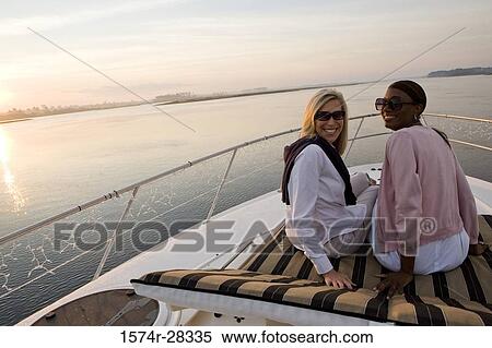 Portrait of friends relaxing on the deck of a boat View Large Photo Image Stock Photography - Portrait of friends relaxing on the deck of a boat. Fotosearch