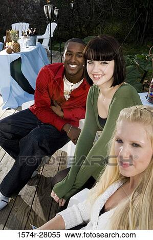 Portrait of friends sitting on armchairs on wooden deck View Large Photo Image Stock Photography - Portrait of friends sitting on armchairs on wooden deck. Fotosearch