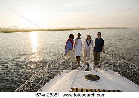 Portrait of friends standing at bow of a boat View Large Photo Image Stock Image - Portrait of friends standing at bow of a boat. Fotosearch