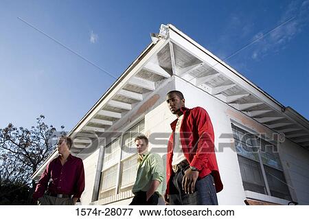 Portrait of friends standing by house View Large Photo Image Stock Photo - Portrait of friends standing by house. Fotosearch