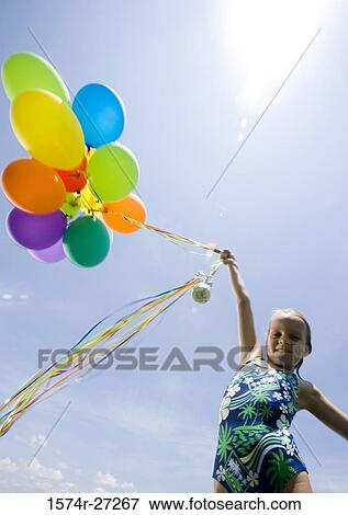Stock Photo - Portrait of girl holding balloons. Fotosearch