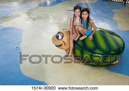 Portrait of girls sitting together on a tortoise sculpture View Large Photo Image Stock Image - Portrait of girls sitting together on a tortoise sculpture. Fotosearch