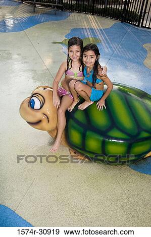 Portrait of girls sitting together on a tortoise sculpture View Large Photo Image Stock Photo - Portrait of girls sitting together on a tortoise sculpture. Fotosearch