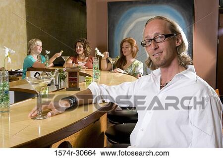 Portrait of mature man sitting by bar counter while wife and daughter behind View Large Photo Image Picture - Portrait of mature man sitting by bar counter while wife and daughter behind. Fotosearch