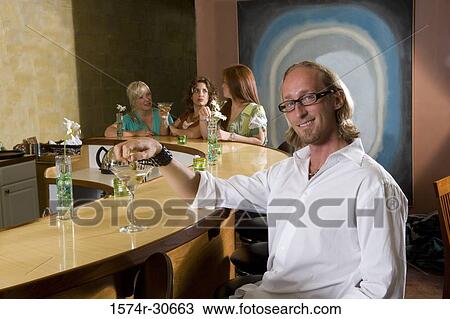 Portrait of mature man sitting by bar counter while wife and daughter behind View Large Photo Image Stock Image - Portrait of mature man sitting by bar counter while wife and daughter behind. Fotosearch