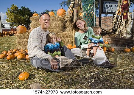 Portrait of parents with their children sitting by straw bundle View Large Photo Image Stock Image - Portrait of parents with their children sitting by straw bundle. Fotosearch