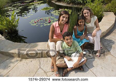 Portrait of people sitting together by pond and smiling View Large Photo Image Picture - Portrait of people sitting together by pond and smiling. Fotosearch