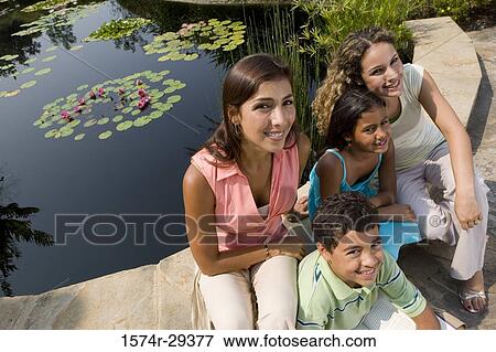 Portrait of people sitting together by pond and smiling View Large Photo Image Stock Photo - Portrait of people sitting together by pond and smiling. Fotosearch