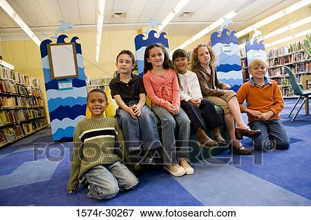 Portrait of schoolboys and girls sitting together in the library View Large Photo Image Stock Photo - Portrait of schoolboys and girls sitting together in the library. Fotosearch