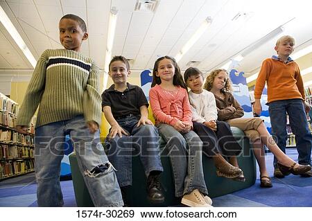Portrait of schoolboys and girls sitting together in the library View Large Photo Image Stock Photo - Portrait of schoolboys and girls sitting together in the library. Fotosearch