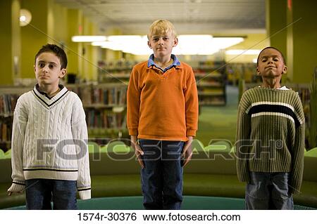 Stock Photograph - Portrait of schoolboys standing in a row in the library. Fotosearch