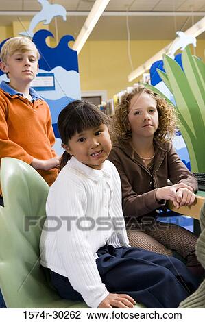 Portrait of schoolgirls and a boy sitting in the library View Large Photo Image Stock Image - Portrait of schoolgirls and a boy sitting in the library. Fotosearch