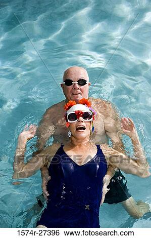 Portrait of senior couple swimming in swimming pool View Large Photo Image Stock Photograph - Portrait of senior couple swimming in swimming pool. Fotosearch