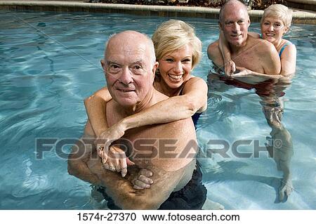 Portrait of senior couples embracing in swimming pool View Large Photo Image Stock Image - Portrait of senior couples embracing in swimming pool. Fotosearch