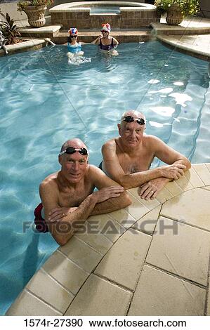 Stock Image - Portrait of senior men in swimming pool while senior women in the background. Fotosearch