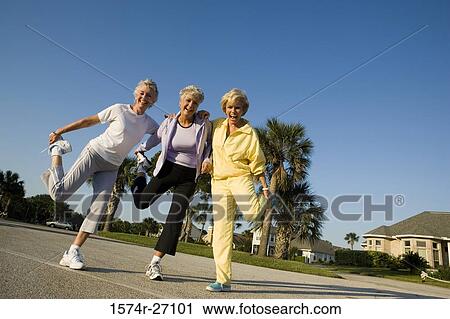 Portrait of senior women laughing while balancing on one leg View Large Photo Image Stock Image - Portrait of senior women laughing while balancing on one leg. Fotosearch