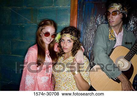 Stock Photo - Portrait of sisters standing together with brother. Fotosearch