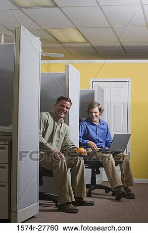Stock Image - Portrait of smiling businessmen sitting in an office. Fotosearch
