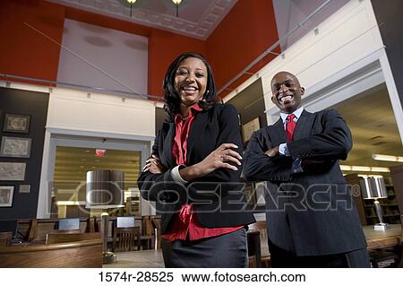 Stock Photography - Portrait of smiling businesspeople standing in an office. Fotosearch