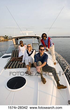 Portrait of smiling friends relaxing on the deck of a boat View Large Photo Image Stock Image - Portrait of smiling friends relaxing on the deck of a boat. Fotosearch