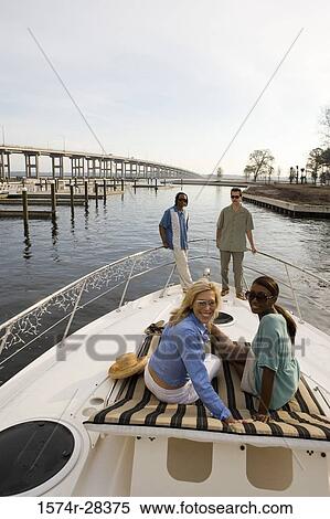 Portrait of smiling friends relaxing on the deck of a boat View Large Photo Image Stock Photography - Portrait of smiling friends relaxing on the deck of a boat. Fotosearch