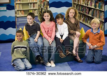 Portrait of smiling schoolboys and girls sitting on sofa in the library View Large Photo Image Stock Image - Portrait of smiling schoolboys and girls sitting on sofa in the library. Fotosearch