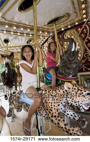 Portrait of teenage girls sitting in an illuminated carousel View Large Photo Image Stock Image - Portrait of teenage girls sitting in an illuminated carousel. Fotosearch