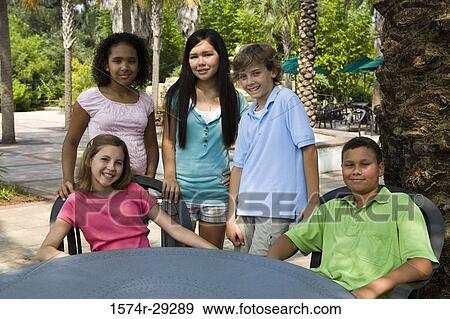 Portrait of teenagers by a table View Large Photo Image Stock Photo - Portrait of teenagers by a table. Fotosearch