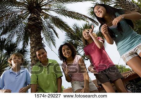 Portrait of teenagers dancing under a palm tree View Large Photo Image Stock Photo - Portrait of teenagers dancing under a palm tree. Fotosearch