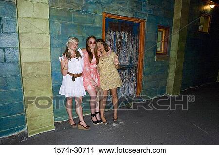 Portrait of women standing together by wall View Large Photo Image Picture - Portrait of women standing together by wall. Fotosearch