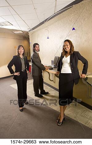 Portrait of young businessmen and businesswoman standing by desk in an office View Large Photo Image Stock Image - Portrait of young businessmen and businesswoman standing by desk in an office. Fotosearch