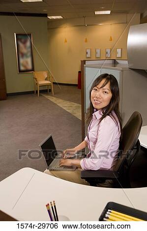 Portrait of young businesswoman working on laptop in an office View Large Photo Image Stock Photograph - Portrait of young businesswoman working on laptop in an office. Fotosearch