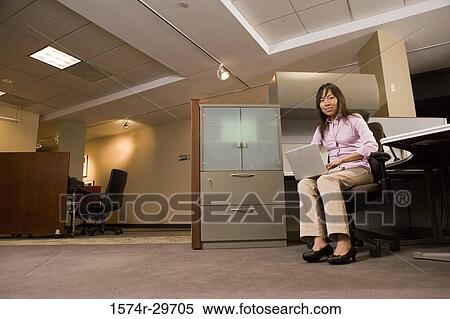 Portrait of young businesswoman working on laptop in an office View Large Photo Image Stock Photography - Portrait of young businesswoman working on laptop in an office. Fotosearch