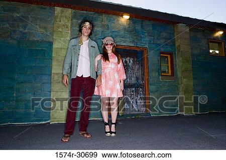 Stock Photo - Portrait of young man standing with her sister. Fotosearch
