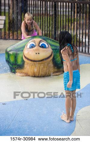 Rear view of a girl standing while other sitting on a tortoise sculpture View Large Photo Image Picture - Rear view of a girl standing while other sitting on a tortoise sculpture. Fotosearch