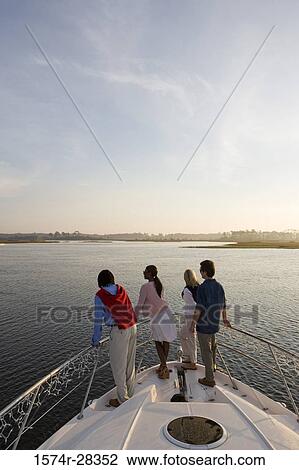 Rear view of friends looking away from the deck of a boat View Large Photo Image Stock Image - Rear view of friends looking away from the deck of a boat. Fotosearch