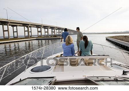 Rear view of friends relaxing on the deck of a boat View Large Photo Image Stock Image - Rear view of friends relaxing on the deck of a boat. Fotosearch