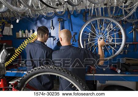Rear view of men working in a workshop View Large Photo Image Stock Photography - Rear view of men working in a workshop. Fotosearch
