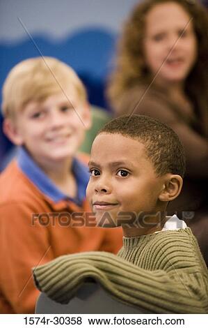 Schoolboy in pullover smiling and looking away View Large Photo Image Stock Photo - Schoolboy in pullover smiling and looking away. Fotosearch