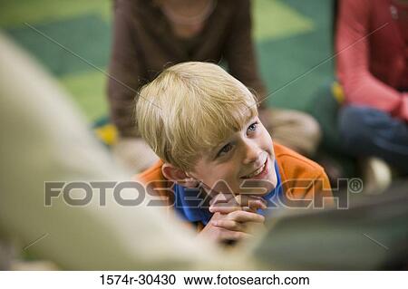 Schoolboy looking up and smiling in the library View Large Photo Image Stock Image - Schoolboy looking up and smiling in the library. Fotosearch