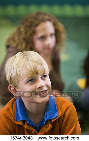 Schoolboy looking up and smiling in the library View Large Photo Image Stock Image - Schoolboy looking up and smiling in the library. Fotosearch