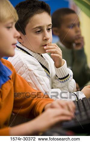 Schoolboy using computer in the library View Large Photo Image Stock Image - Schoolboy using computer in the library. Fotosearch