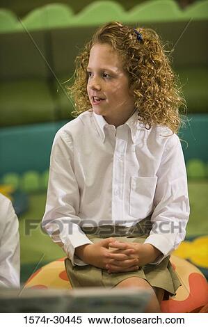 Schoolgirl in uniform sitting with hands clasped on stool View Large Photo Image Stock Photography - Schoolgirl in uniform sitting with hands clasped on stool. Fotosearch
