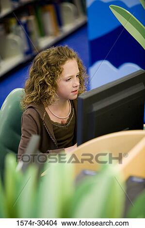 Schoolgirl using computer in the library View Large Photo Image Picture - Schoolgirl using computer in the library. Fotosearch