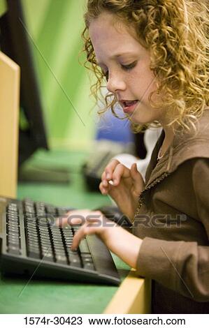 Schoolgirl using computer keyboard in the library View Large Photo Image Stock Image - Schoolgirl using computer keyboard in the library. Fotosearch