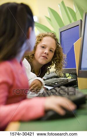Schoolgirls using computers in the library View Large Photo Image Stock Image - Schoolgirls using computers in the library. Fotosearch